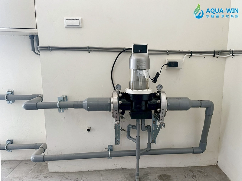 Close-up of whole-house backwash pre-filter with PVC piping configuration for sediment removal